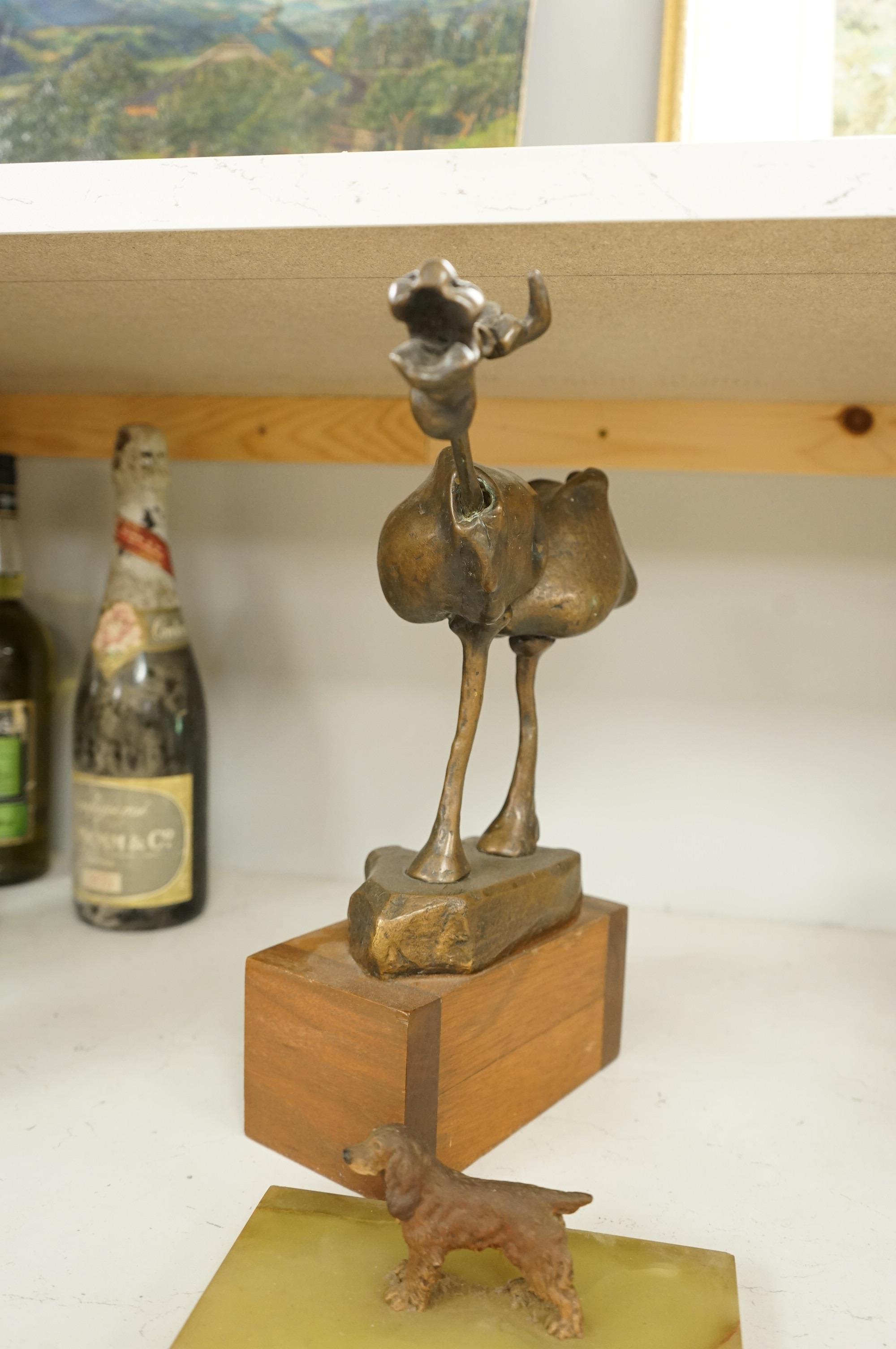 An abstract bronze model of a cow, 34cm and an Art Deco green onyx box, the lid surmounted with a cold painted bronze spaniel, 16.5cm wide.